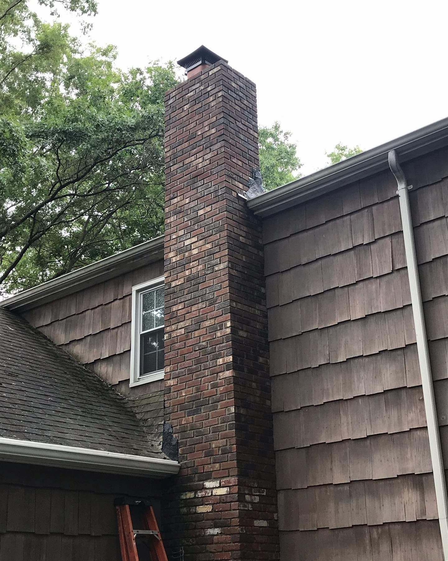 Tall brick chimney running up the side of a shingle-sided Wayne, PA home