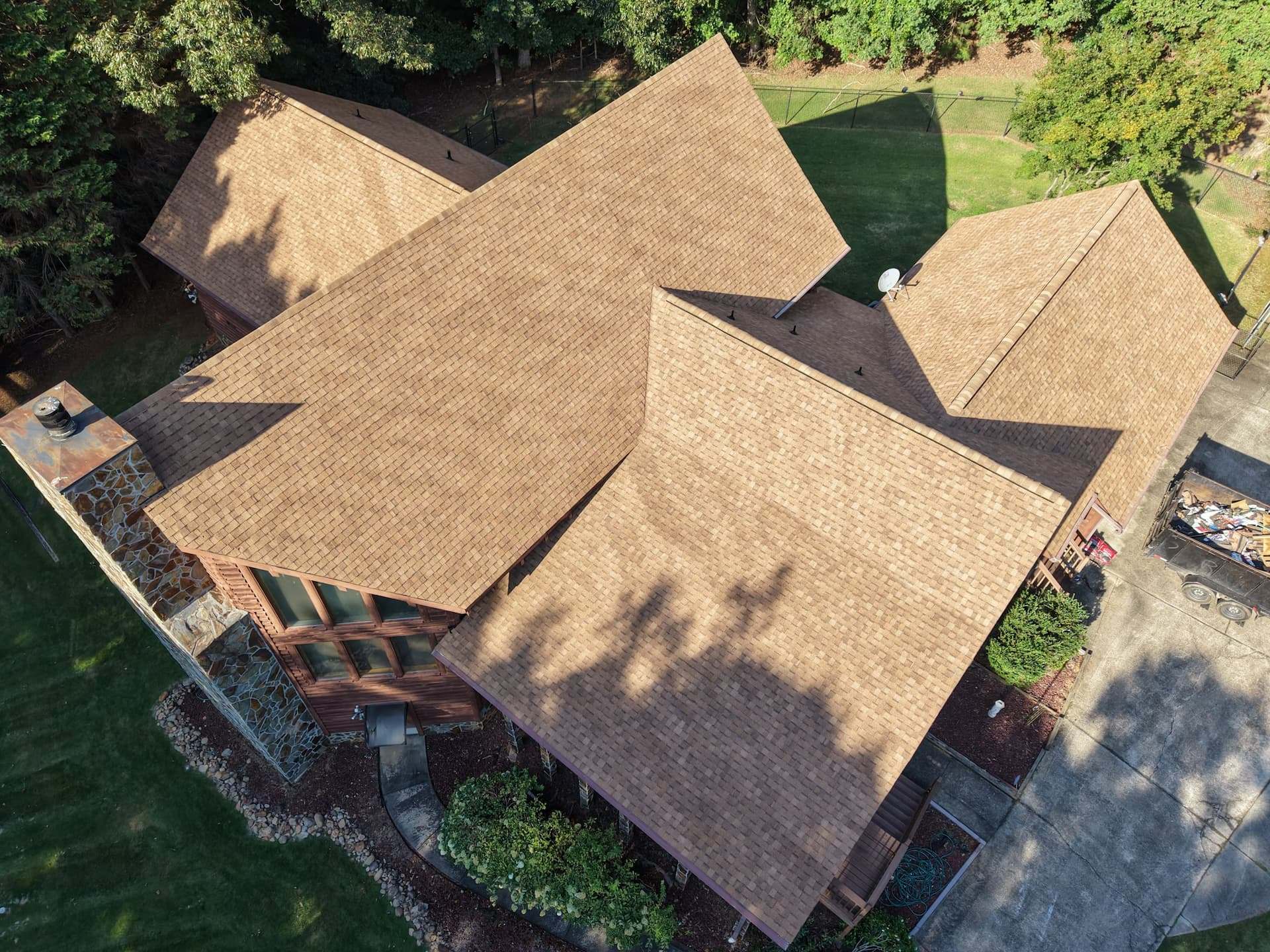 Aerial view of the same house with its new brown architectural shingle roof finished
