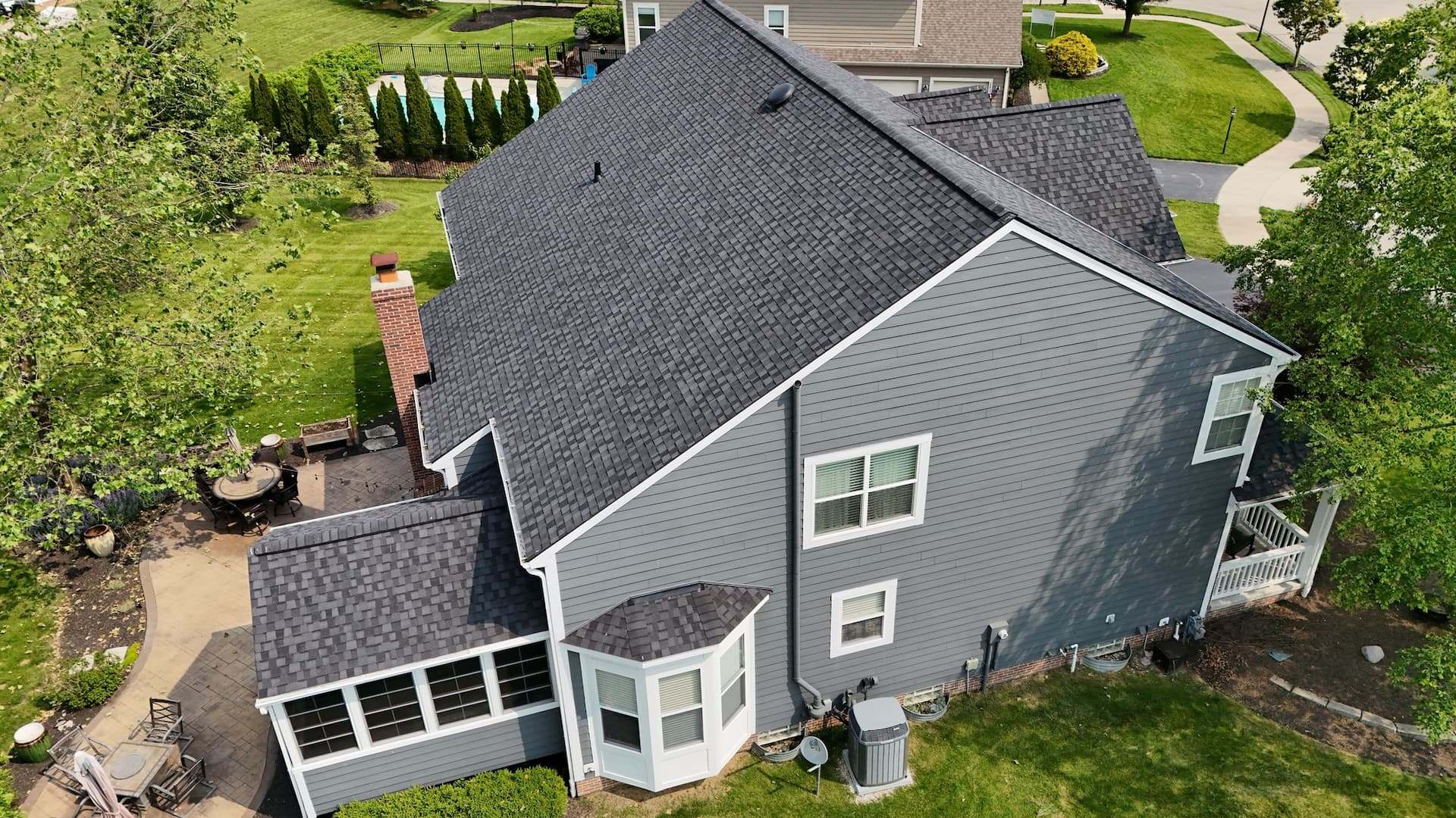 Aerial view of a new dark shingle roof on a two-story Wayne, PA home with grey siding