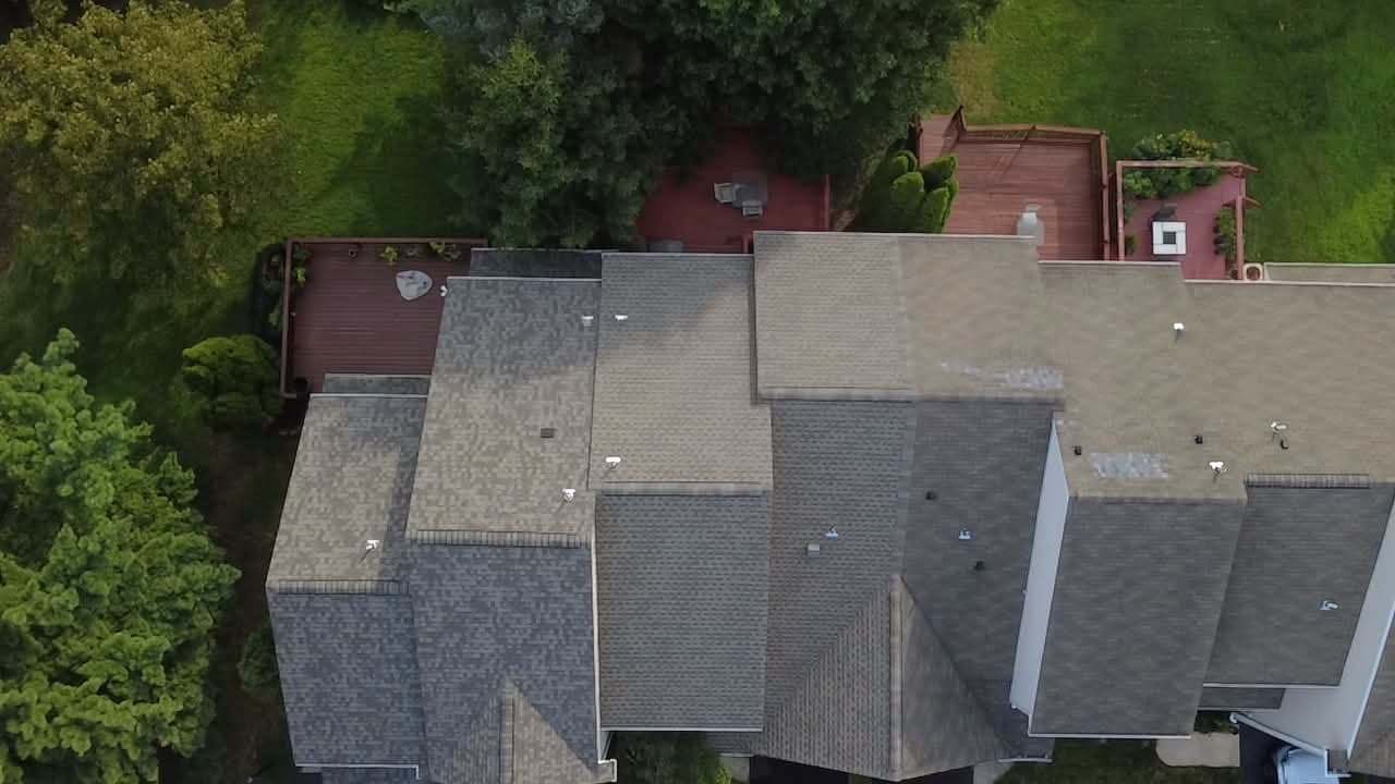 Overhead drone view of a row of attached homes with the new shingle roof finished